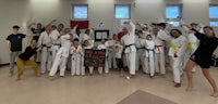 a group of people posing for a photo in a karate class